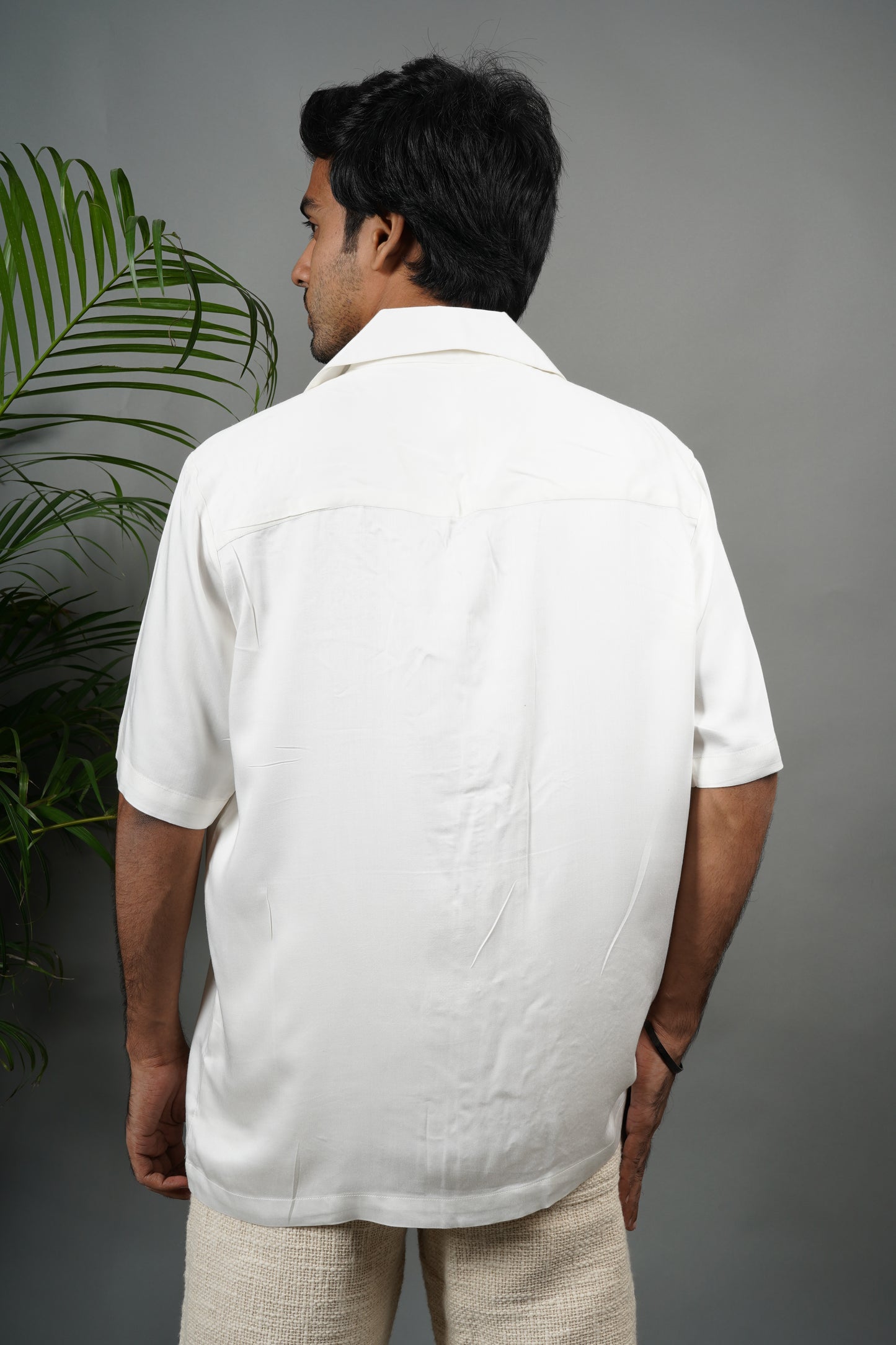 "Handmade white Cuban collar shirt made from soft modal fabric with intricate  embroidery featuring floral and leaf patterns on the shoulder and pocket."
