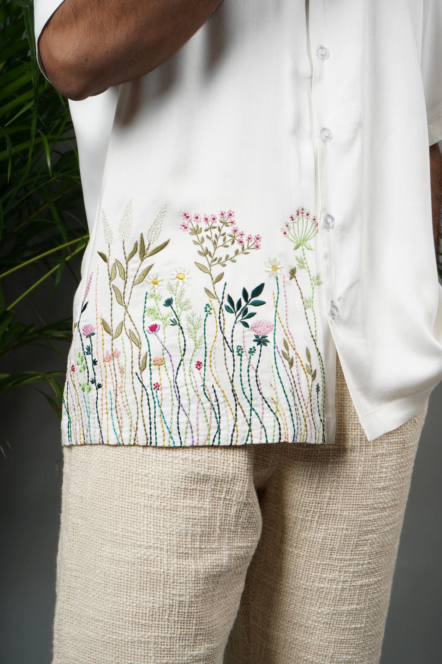 "Handmade white Cuban collar shirt made from soft modal fabric with intricate embroidery featuring floral and leaf patterns on the shoulder and pocket."
