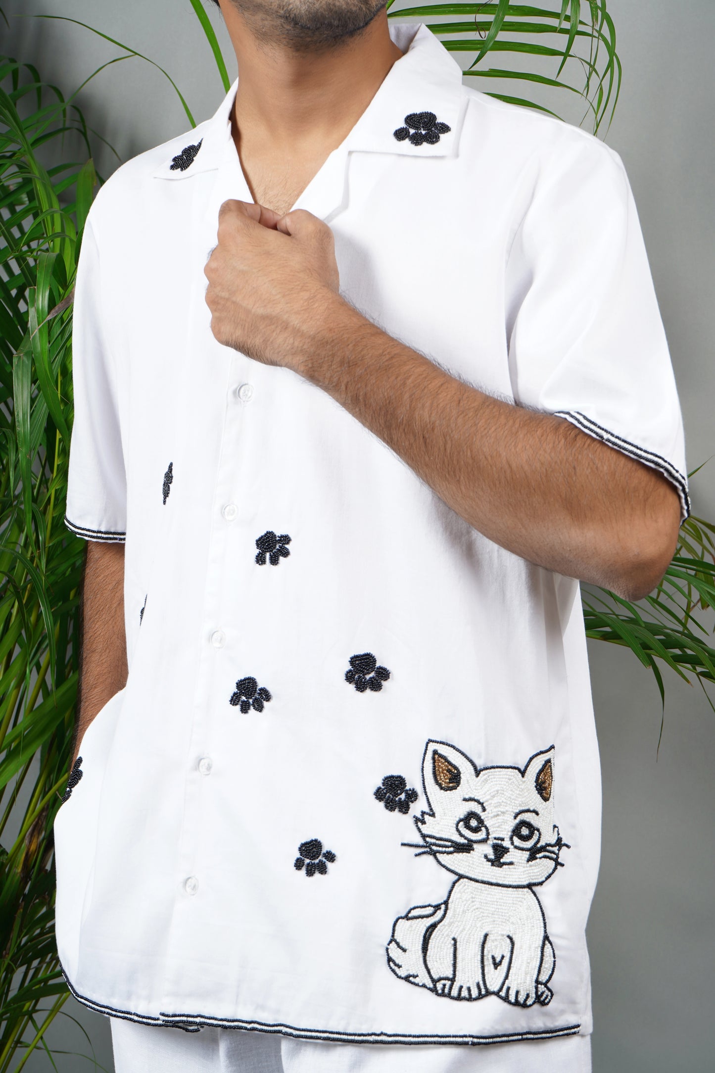 Handmade white cotton shirt with embroidered cat design and black floral accents, playful luxury embroidered shirt for men.
