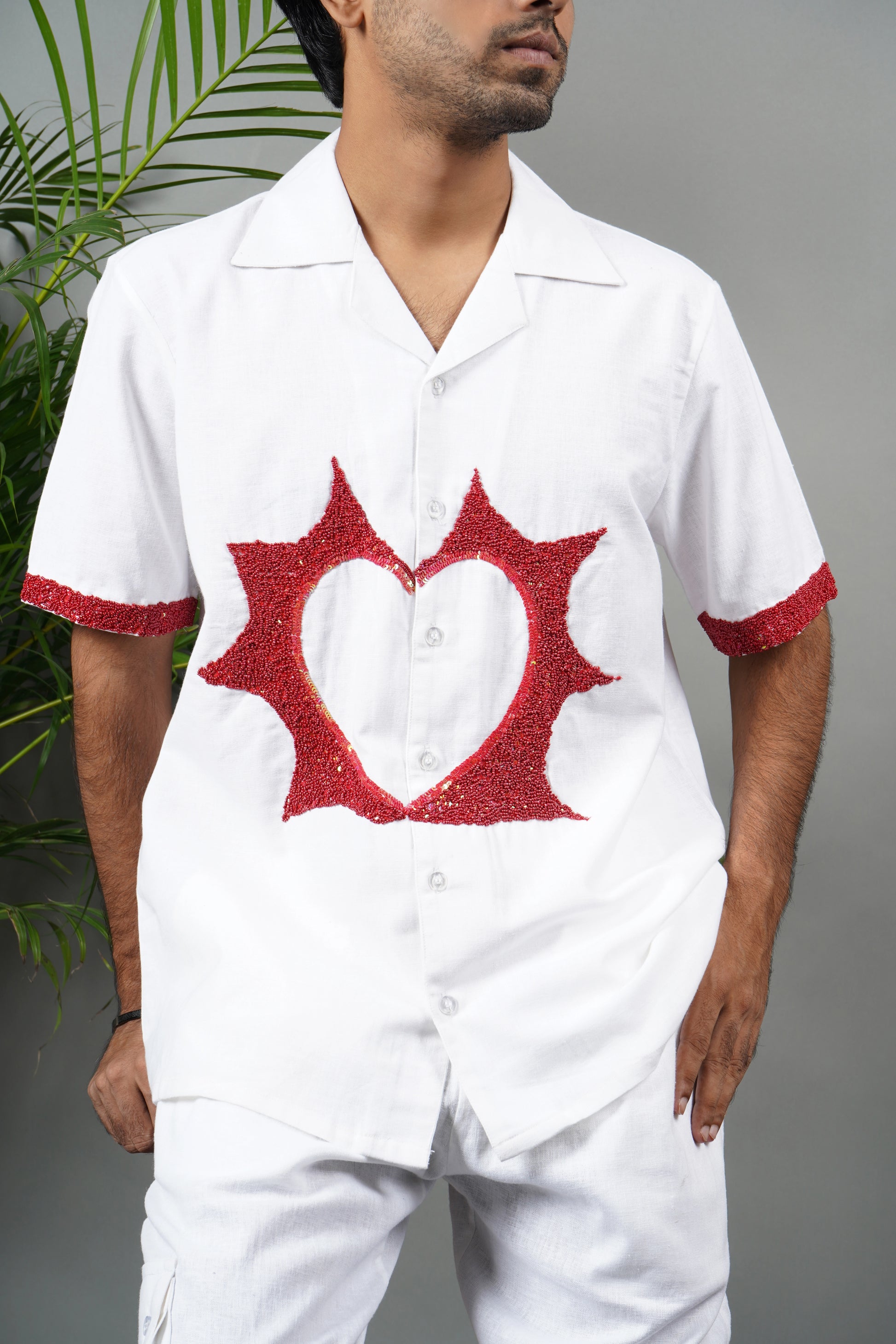 Handmade white linen blend shirt with bold red anatomical heart embroidery, unique hand-embroidered statement shirt, luxury fashion.
