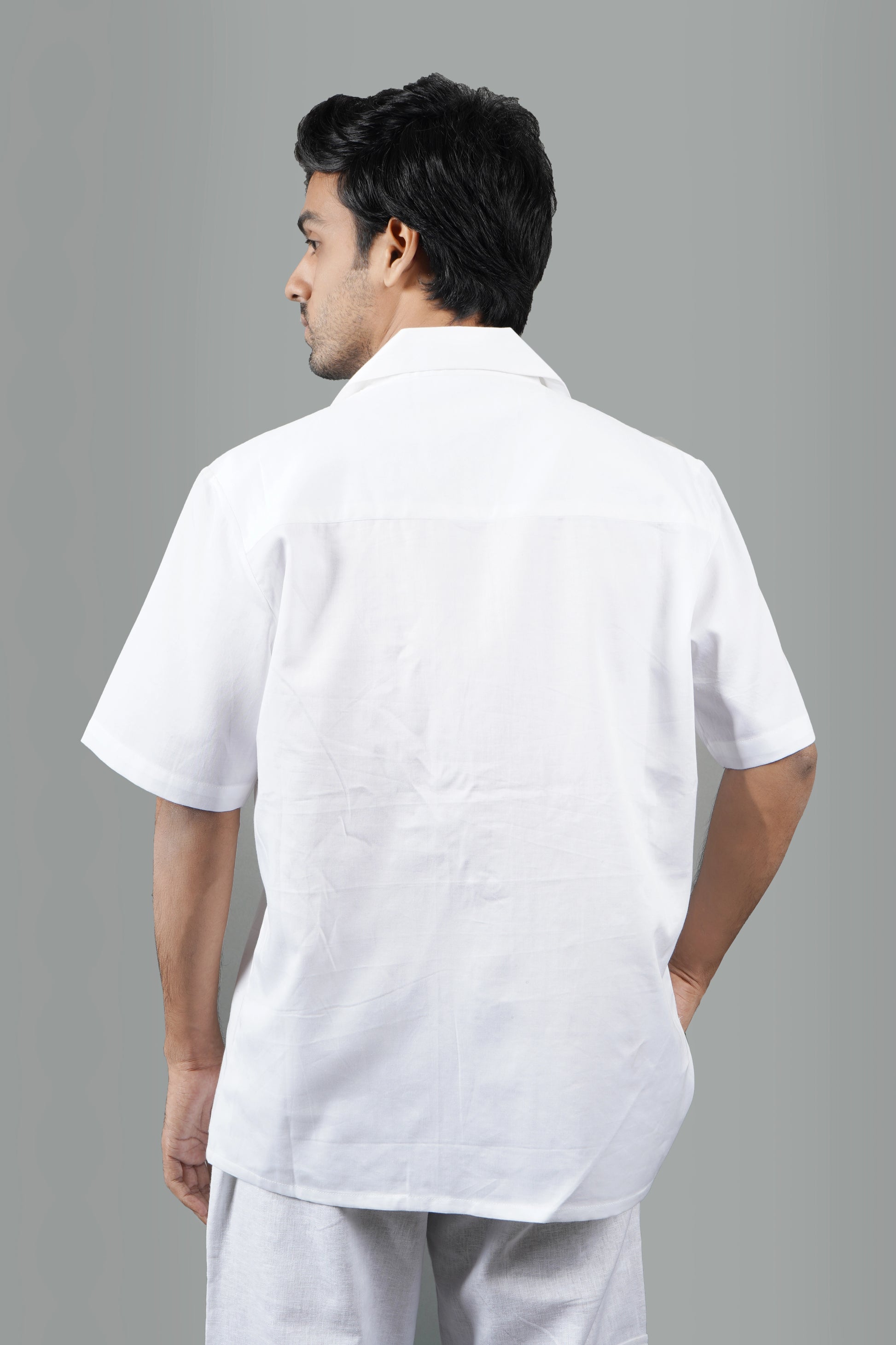 Handmade white cotton shirt with vibrant hand-embroidered tropical palm tree and sun design, luxury summer wear for men, unique artisanal embroidery.

