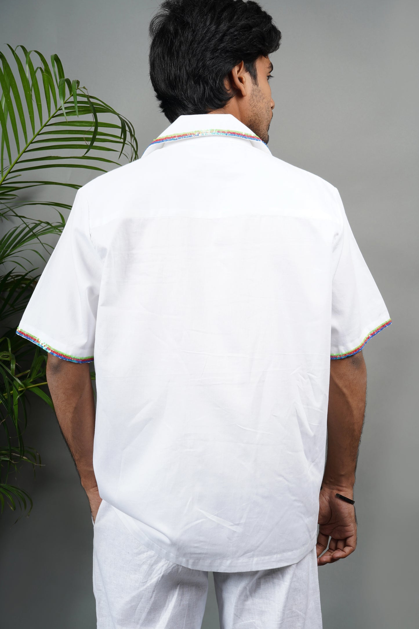 "White Cuban collar shirt with playful hand embroidery of colorful balloons and rainbow piping details. Modern and artistic design made from breathable, premium cotton fabric."

