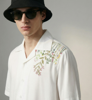 Close up of hand embroidered botanical flowers on white 100% cotton Cuban collar shirt, detailed handmade floral embroidery design