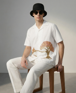 Man wearing white embroidered Cuban collar shirt with tree and swing design, stylish cotton summer outfit for men