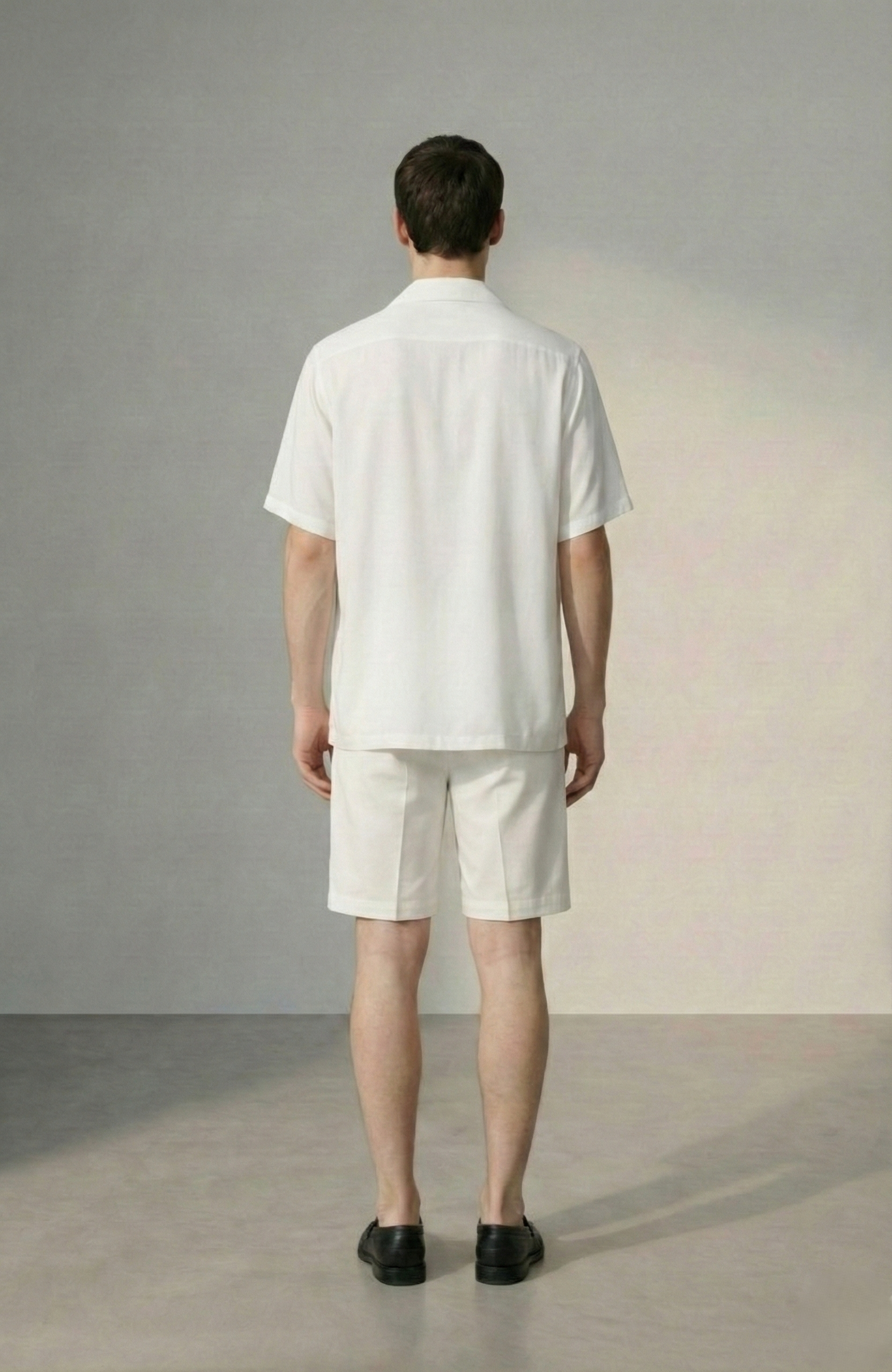 Back view of mens white Cuban collar summer shirt with relaxed fit and matching white shorts