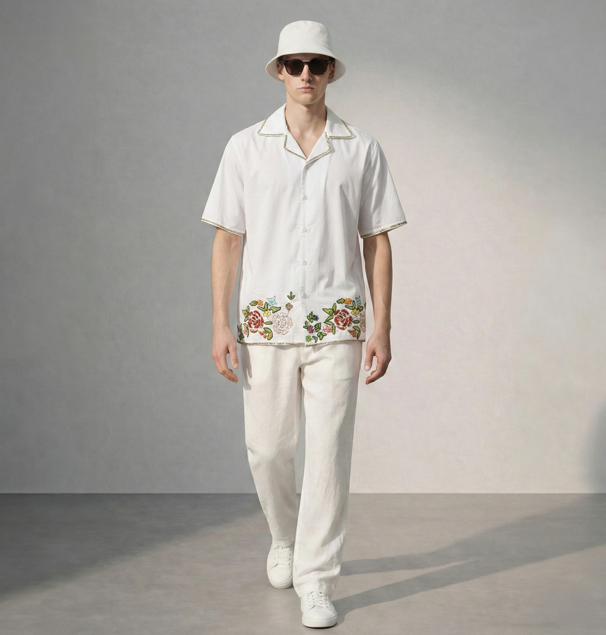 Man wearing white cotton Cuban collar shirt with floral embroidered hem, stylish summer resort outfit for men
