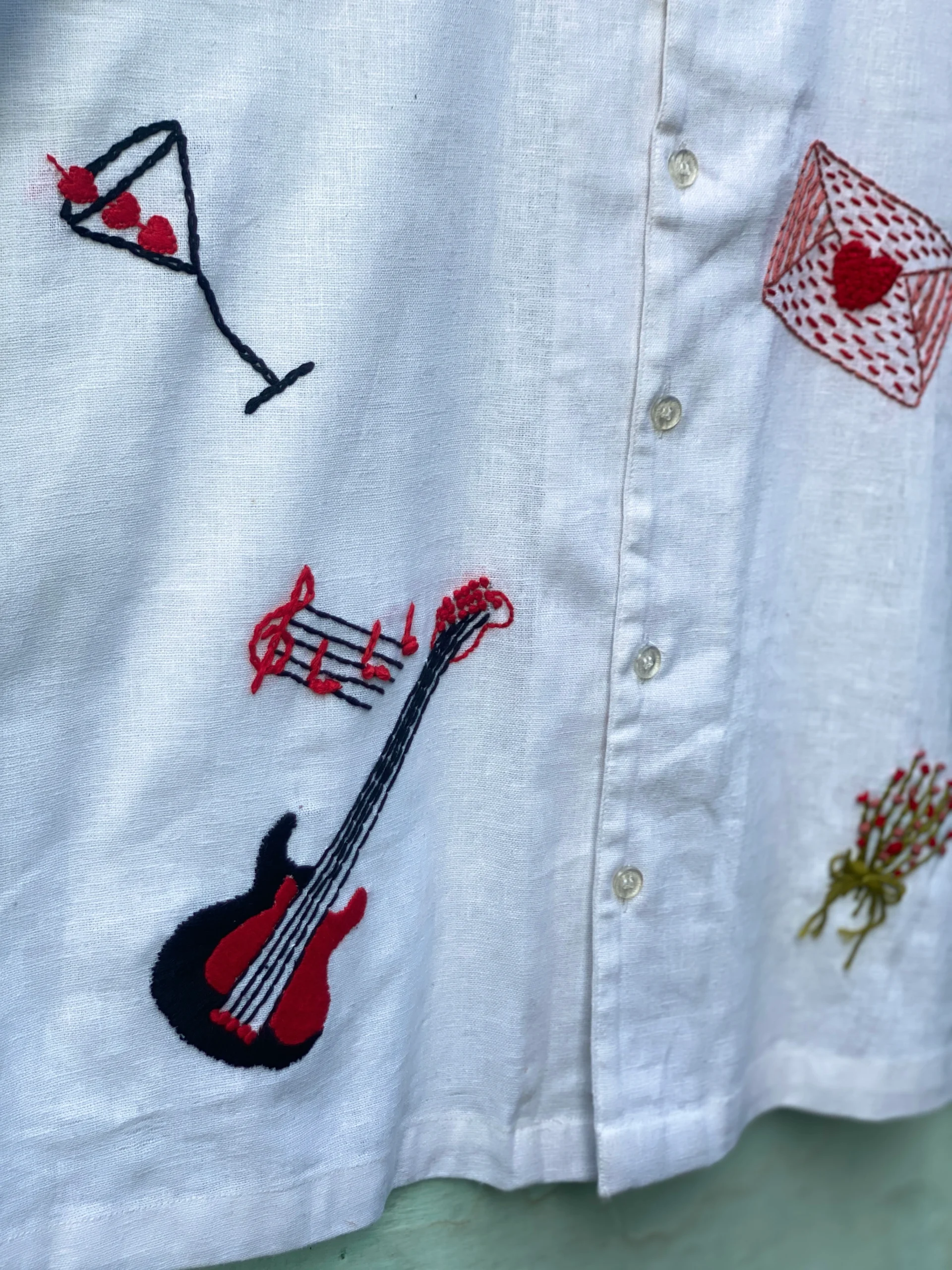 "Handmade linen cotton shirt with colorful hand embroidery including guitar, cherries, cake, and love motifs – limited edition Cuban collar shirt by Liibula"
