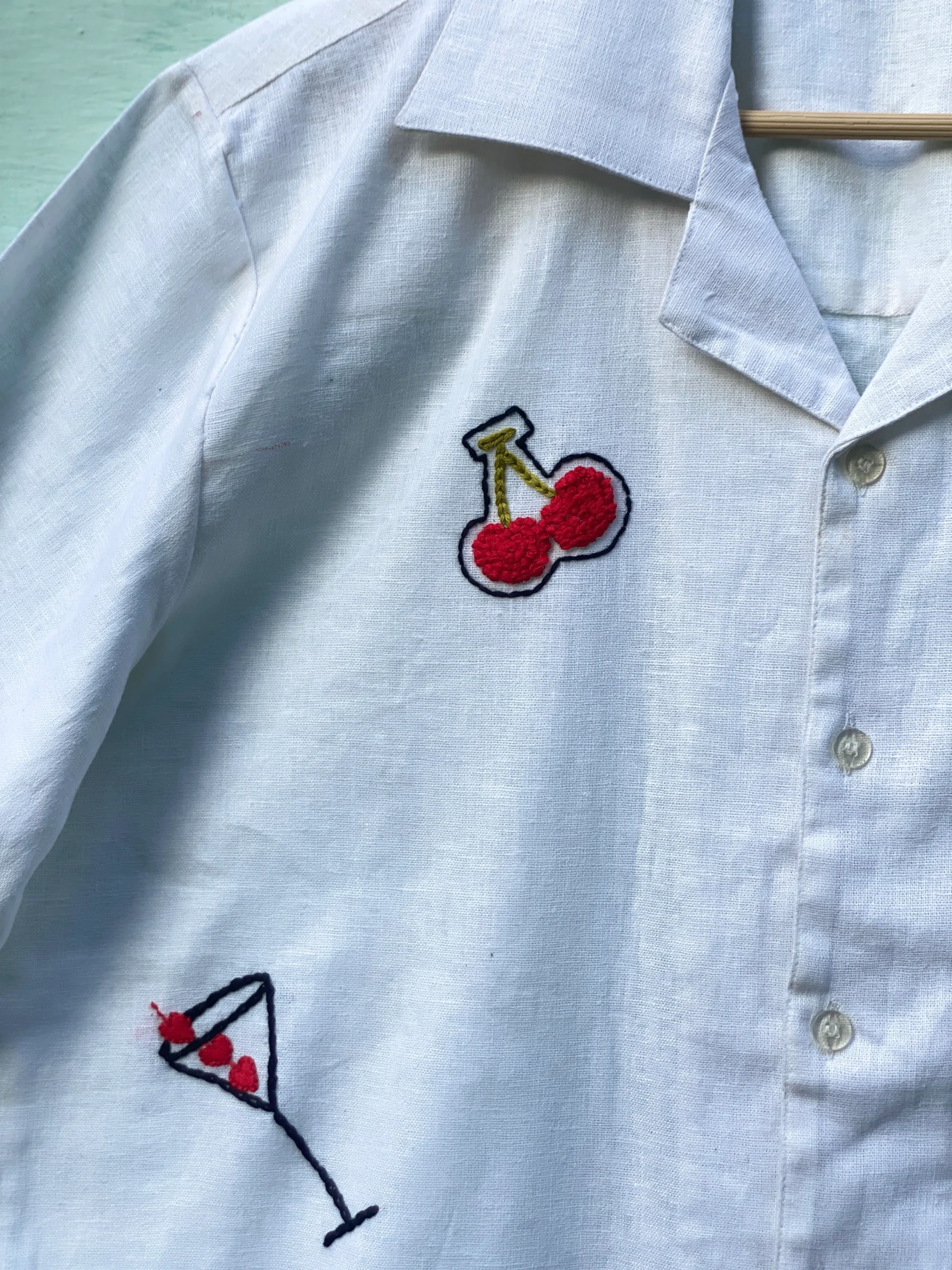 "Handmade linen cotton shirt with colorful hand embroidery including guitar, cherries, cake, and love motifs – limited edition Cuban collar shirt by Liibula"