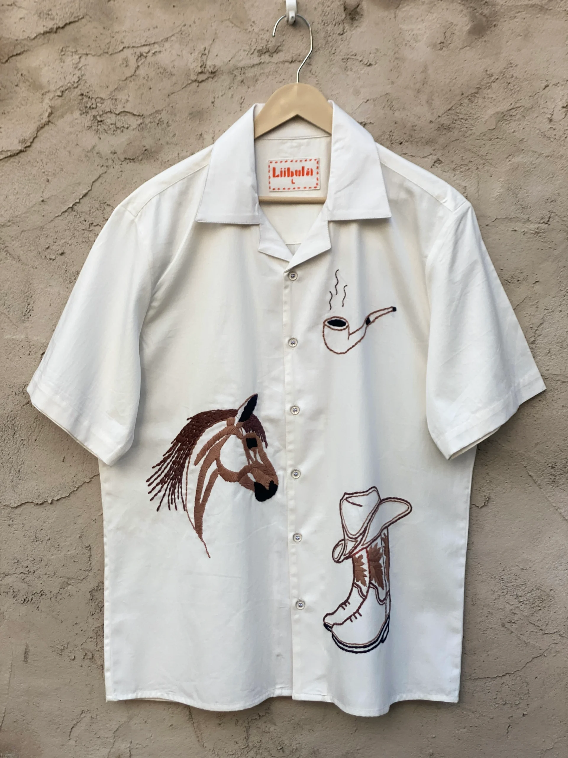 Handmade 100% cotton Cuban-collar shirt with cowboy-themed embroidery including horse, hat, boots, and pipe