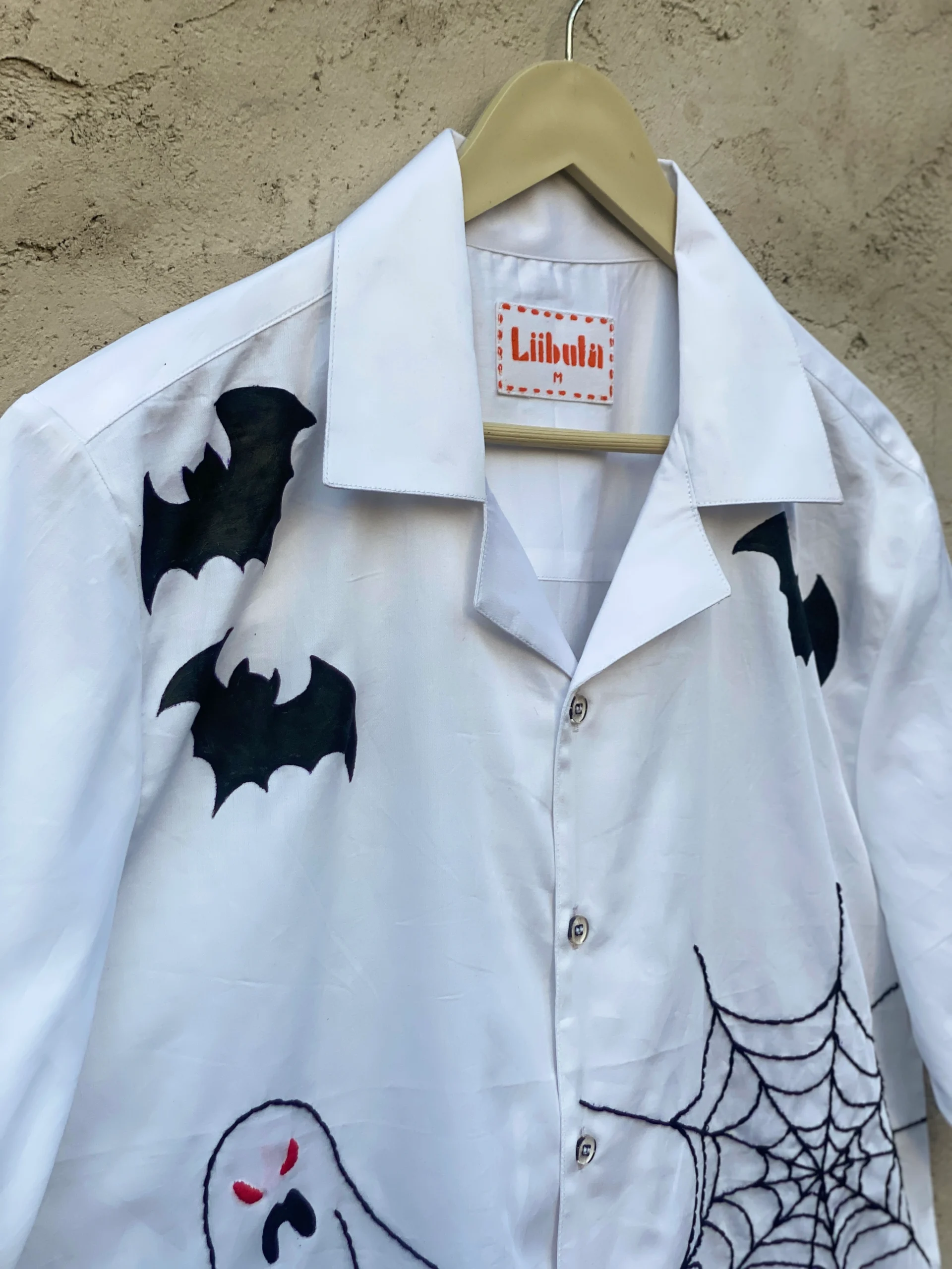 White cotton shirt with hand embroidery of bats, ghost, pumpkin, and spider web