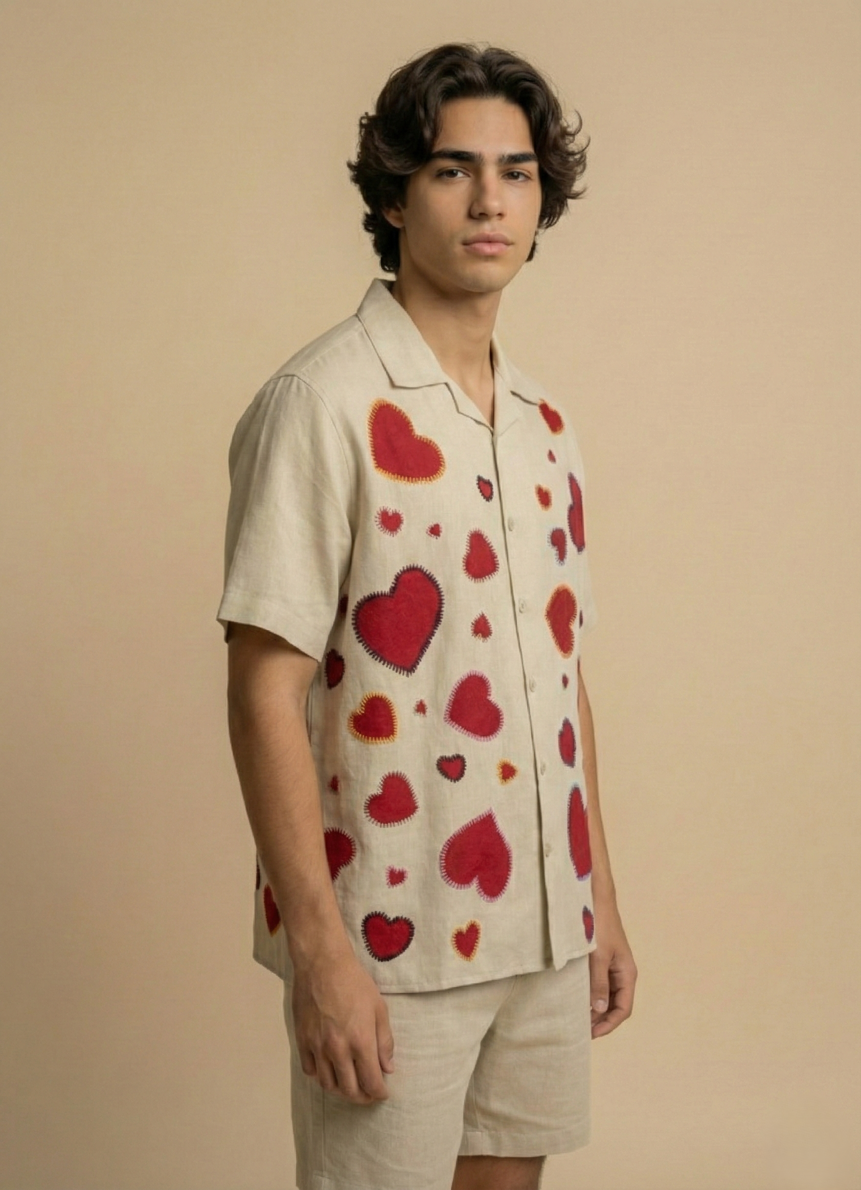 Side view of mens beige Cuban collar shirt with red heart embroidery, breathable summer resort wear with relaxed fit silhouette