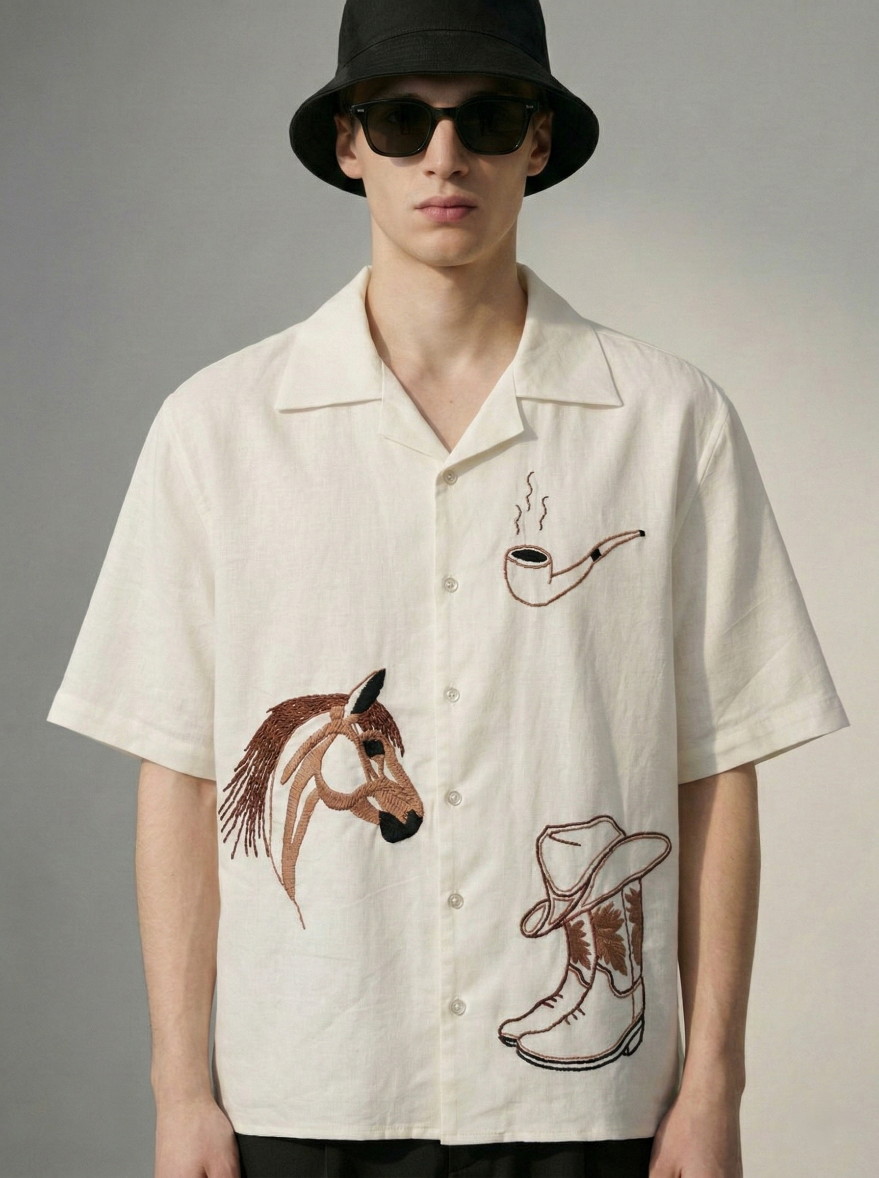 Close up of cowboy embroidery on mens shirt featuring horse head and boots design, detailed handmade stitching on premium cotton linen fabric
