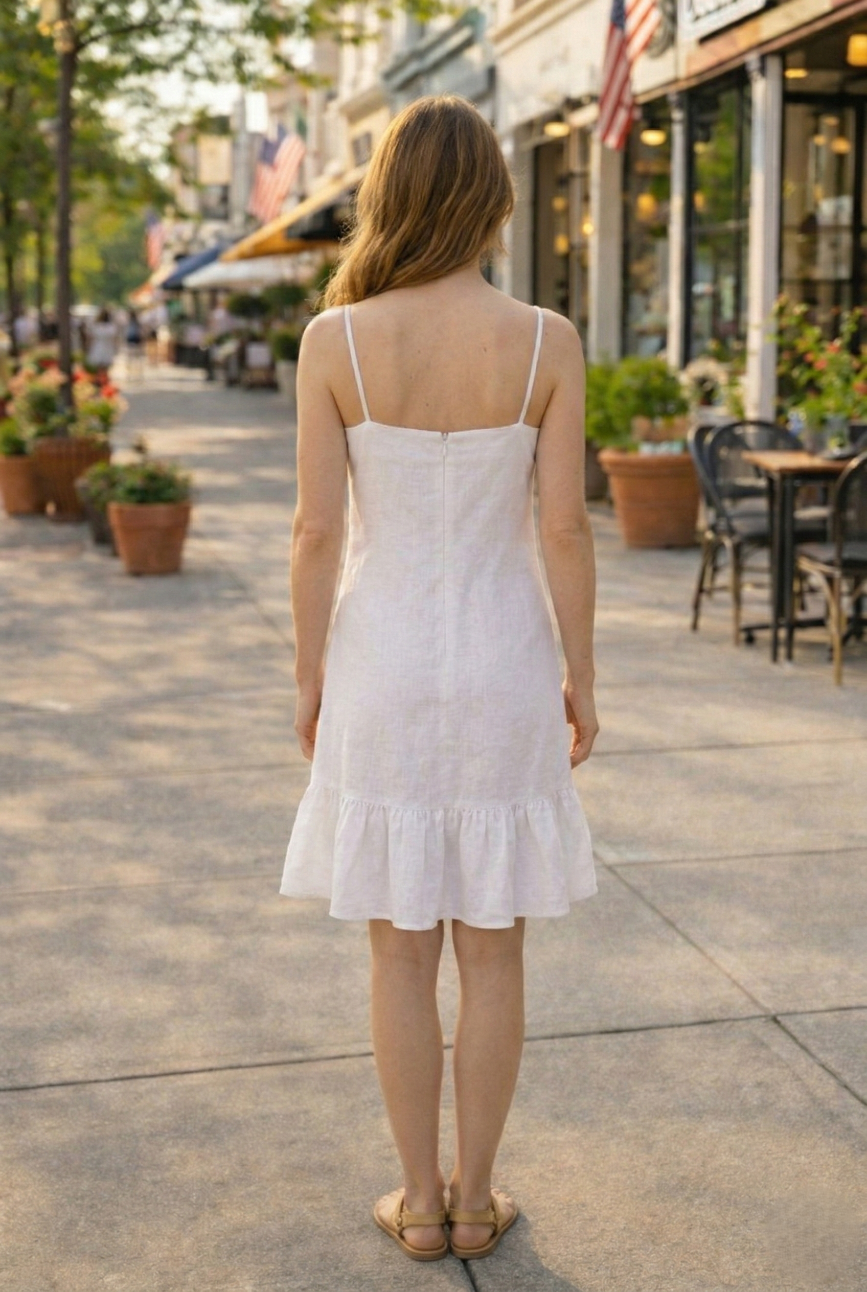 Back view of white linen cotton floral dress with adjustable straps and zipper