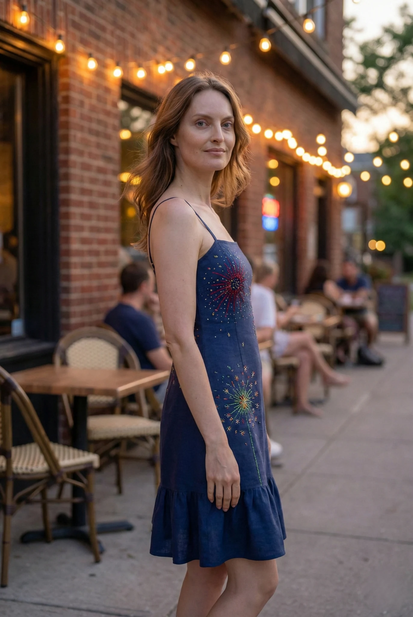 side view of navy blue embroidered summer dress with fireworks design worn outdoors cafe aesthetic linen cotton dress